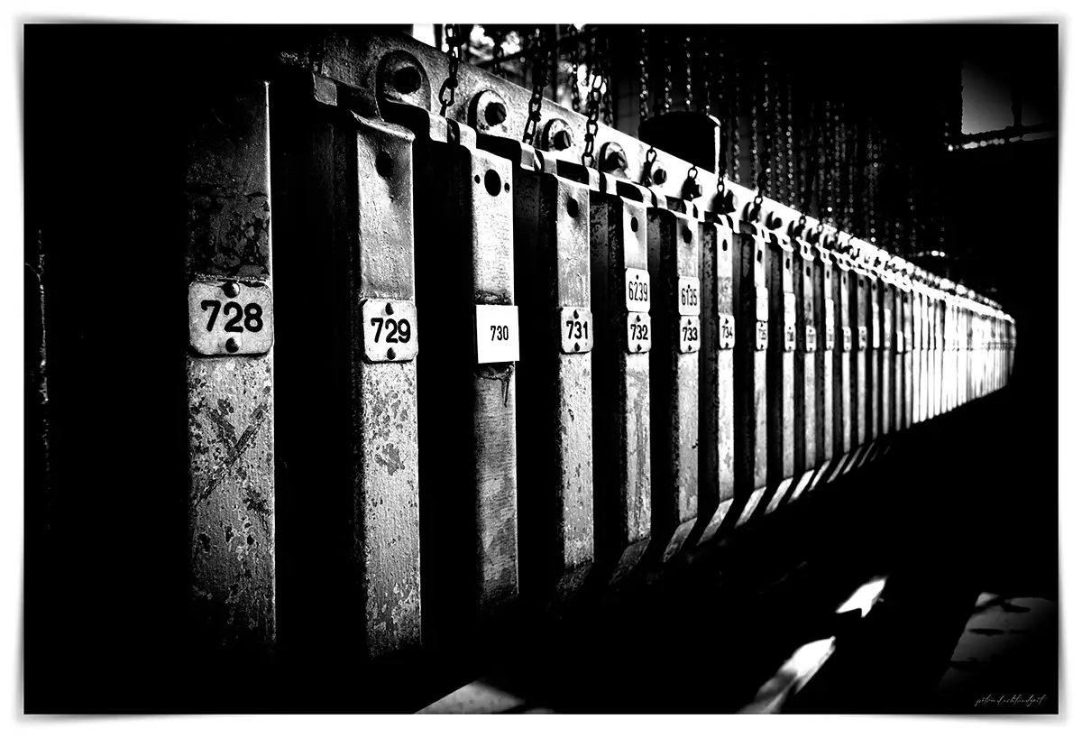 Schwarz-Weiß-Aufnahme nummerierter Kleiderkästen mit Ketten in der Kokerei Hansa.